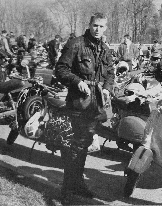 Stefan in Lederkleidung mit Helm in der Hand an einem Motorroller bei einem Rollertreffen, Schwarzweiß
