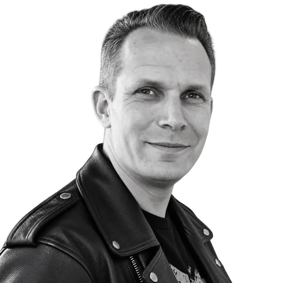 Stefan „Buster“ Struppe, Porträt in Schwarzweiß, lächelnd, in schwarzer Lederjacke